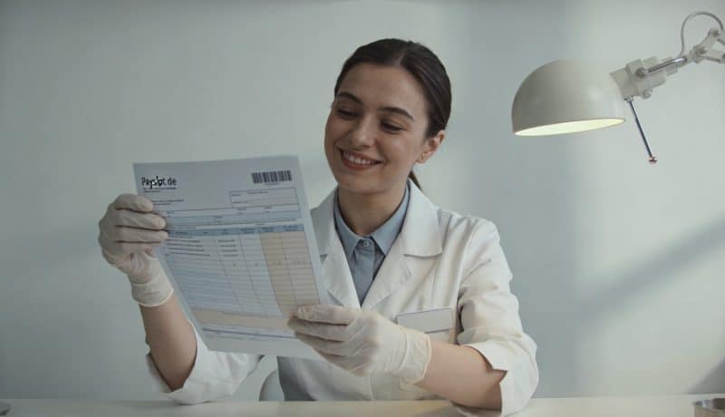 Assistante dentaire souriante consulte fiche de paie