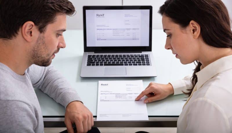 couple assis devant ordinateur examinant quittance de loyer