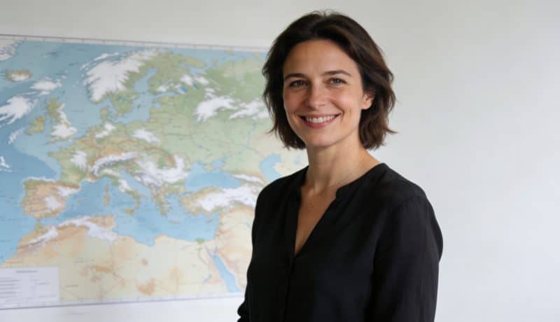 Evelyne Dheliat souriante devant carte meteo en studio