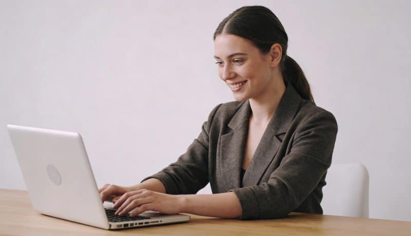 jeune femme etrangere souriante travaillant sur ordinateur portable