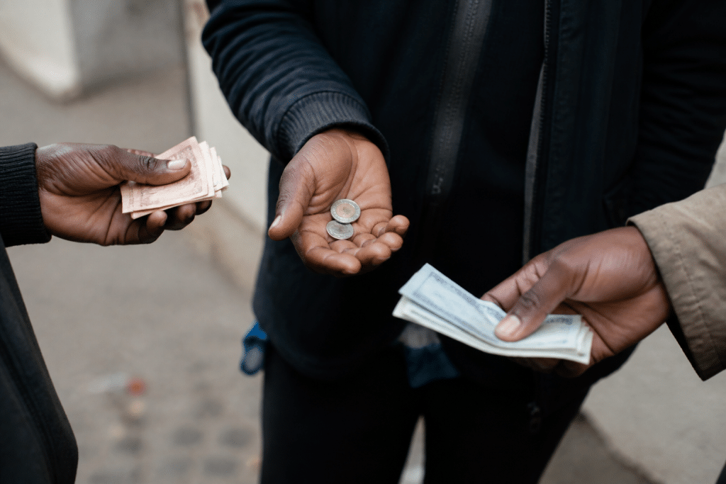 Billets et pieces monnaie repartis entre trois mains differentes
