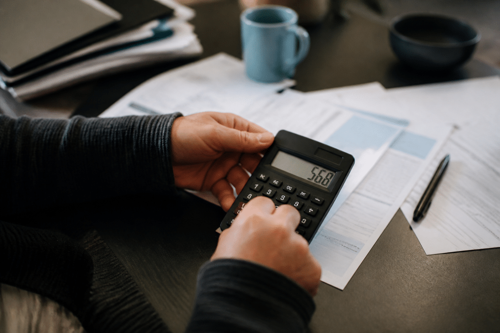 Calculatrice affichant 568 euros, documents administratifs RSA et APL