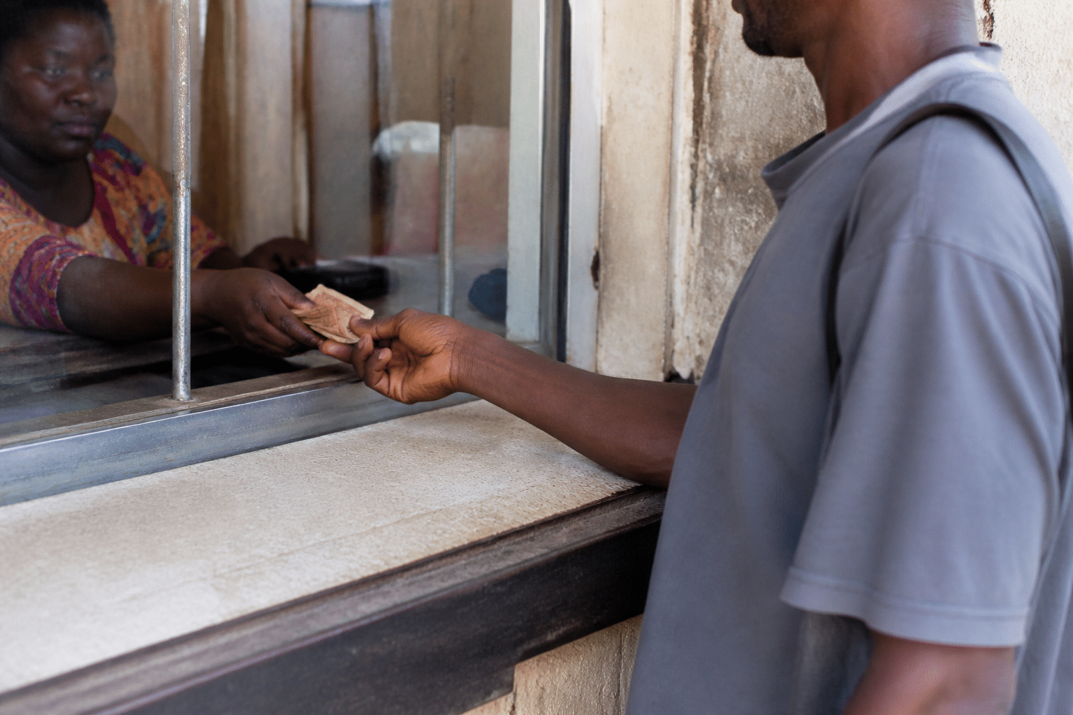 Client remettant des billets de banque au guichet.