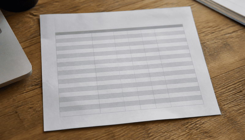 Document papier affichant tableau salaires sur bureau.