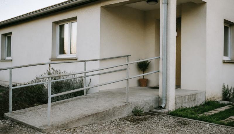 Facade de maison basse avec rampe d'acces pour mobilite reduite.