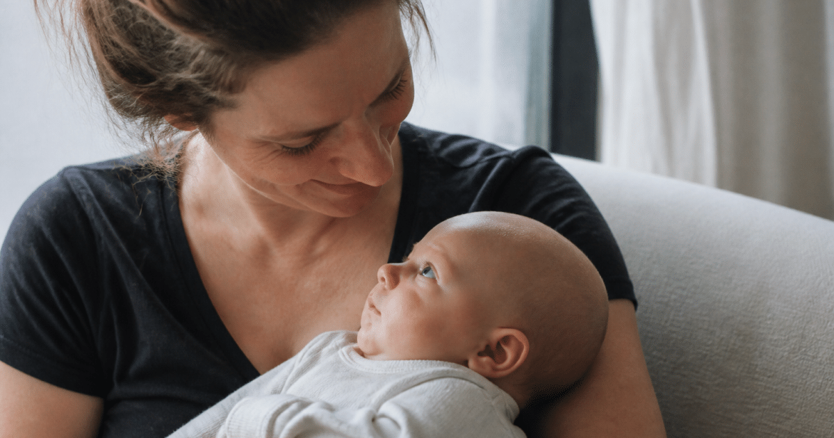 Femme tenant bébé dans ses bras bienveillants.