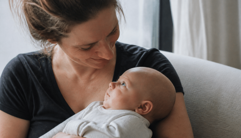Femme tenant bébé dans ses bras bienveillants.