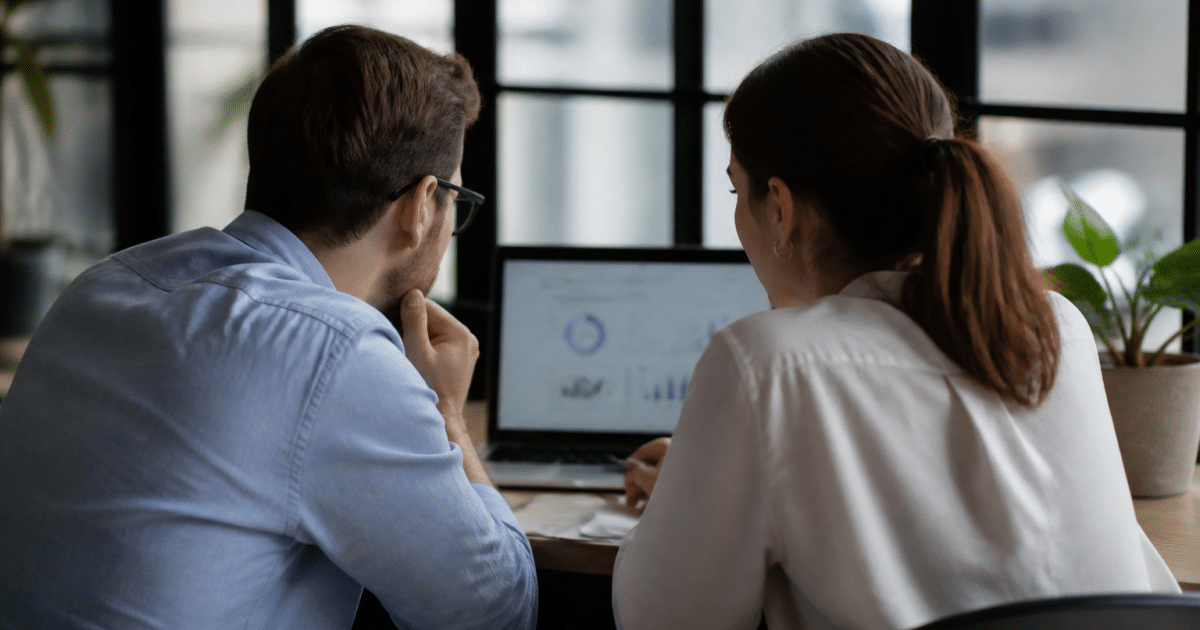 Hommes et femmes consulter statistiques emploi sur écran ordinateur
