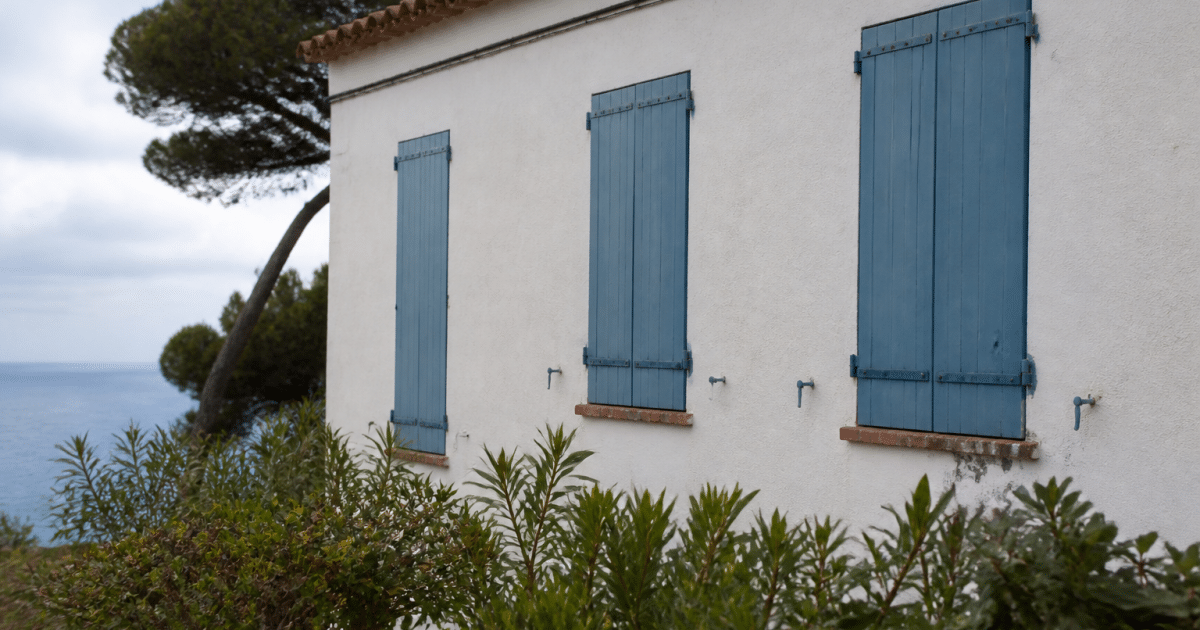 Maison côtière méditerranéenne avec volets bleus fermés