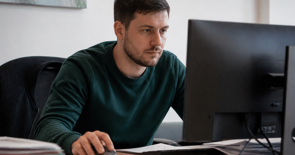 Moniteur educateur assis face ordinateur bureau documents