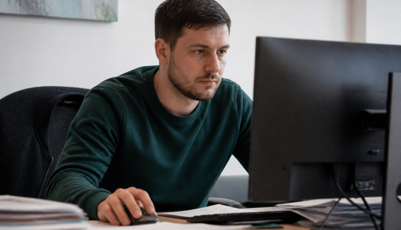 Moniteur educateur assis face ordinateur bureau documents