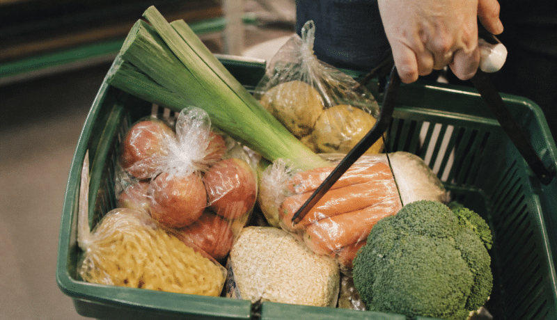 Panier d'epicerie avec legumes frais et paquets aliments economiques.