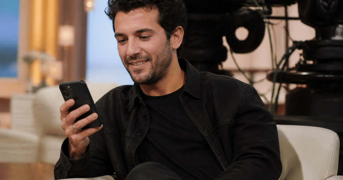 Participant tenant un telephone sur plateau television enregistre