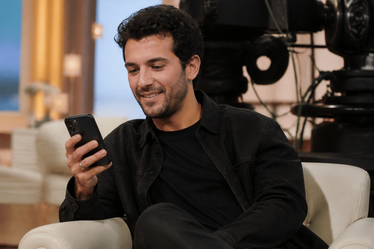 Participant tenant un telephone sur plateau television enregistre