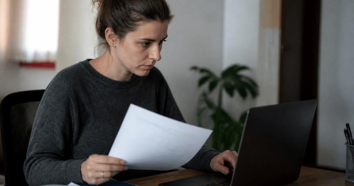 Personne assise devant ordinateur consultantdocuments administratifs emploi.