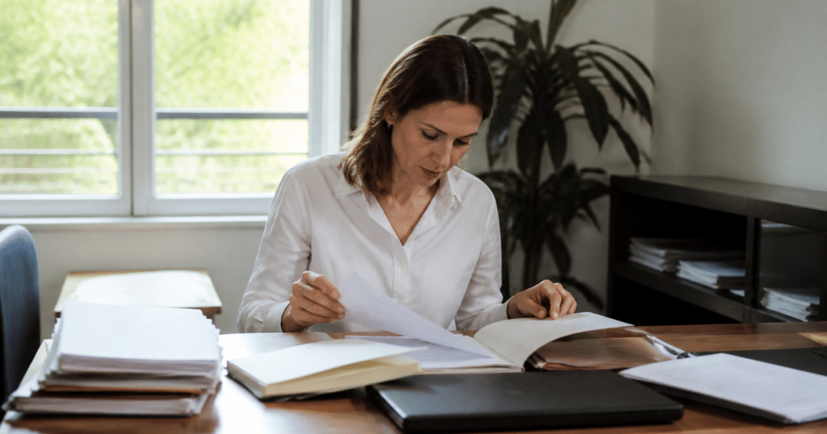 Personne consultant documents papier sur bureau organisé