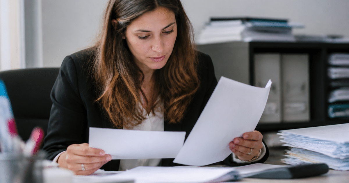 Personne consultant documents fiscaux et formulaire administratif bureau.