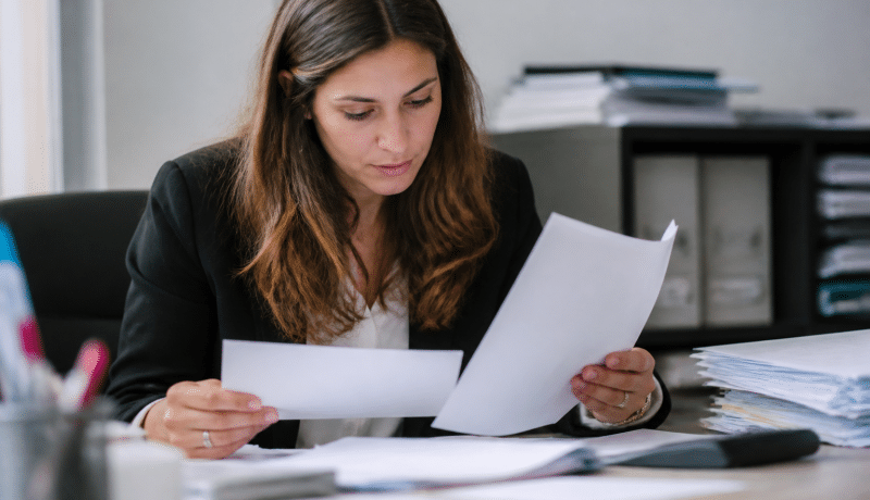 Personne consultant documents fiscaux et formulaire administratif bureau.