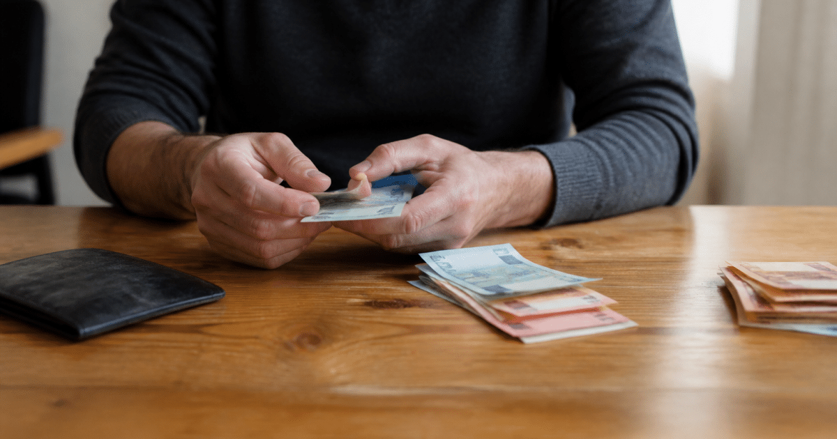 Personne comptant des billets d'euros sur table