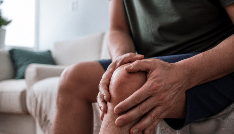 Personne tenant son genou douloureux avec ses deux mains