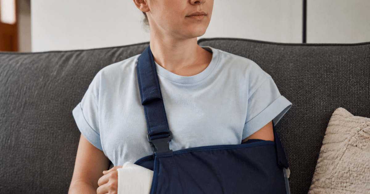 Personne immobilisée avec attelle main et bras en repos médical.