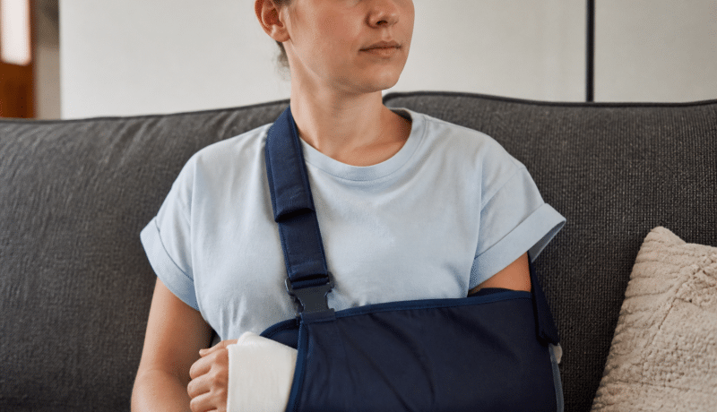 Personne immobilisée avec attelle main et bras en repos médical.