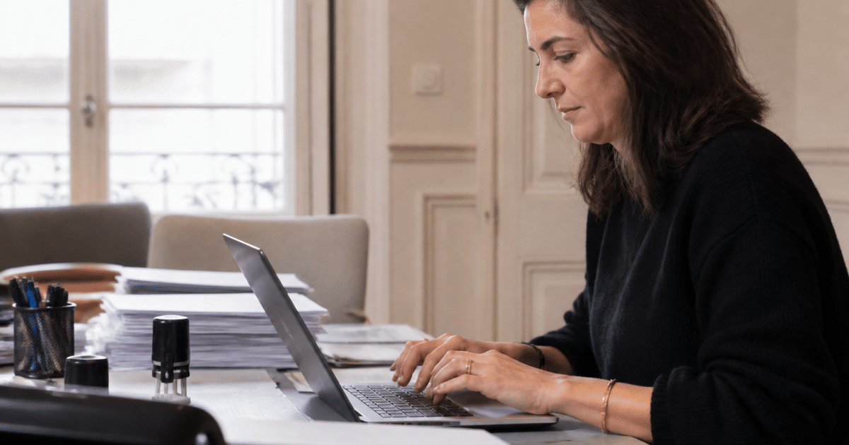 Personne tapant email sur ordinateur portable bureau notaire