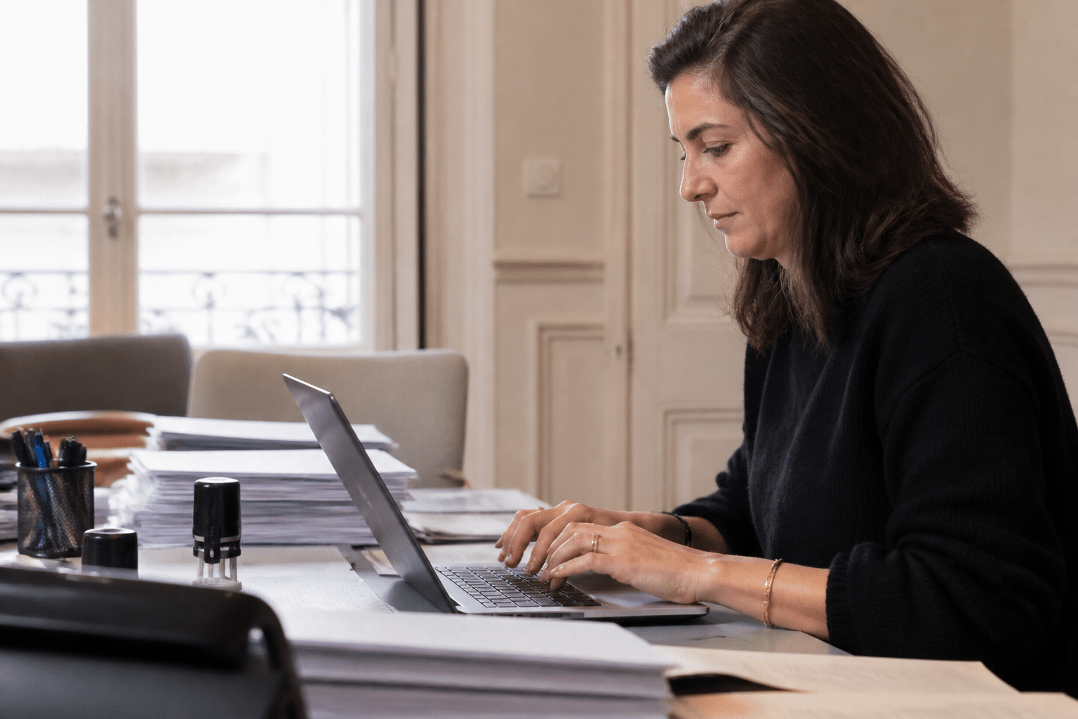 Personne tapant email sur ordinateur portable bureau notaire