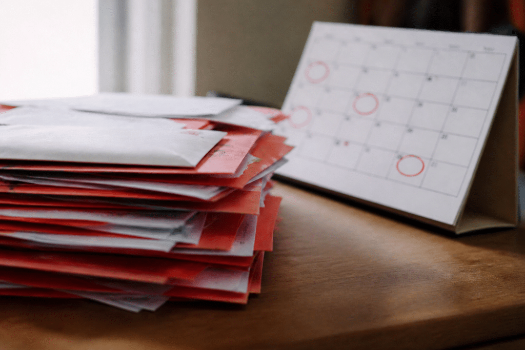 Pile de factures rouges et calendrier avec dates encerclees.