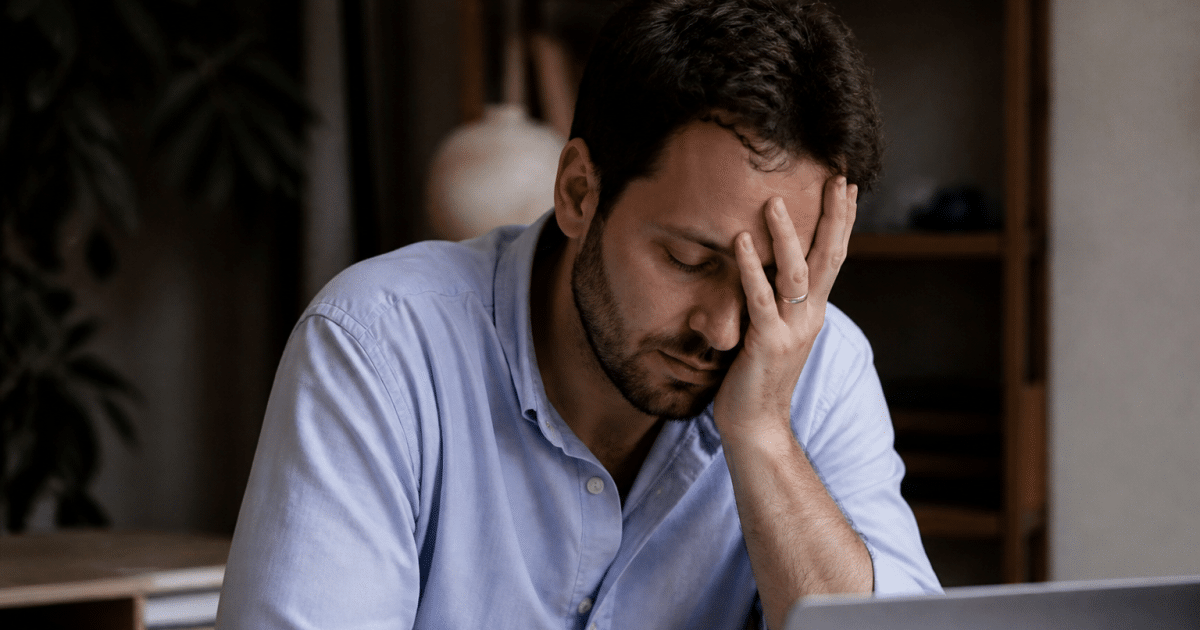 Travailleur fatigué à son bureau tenant sa tête