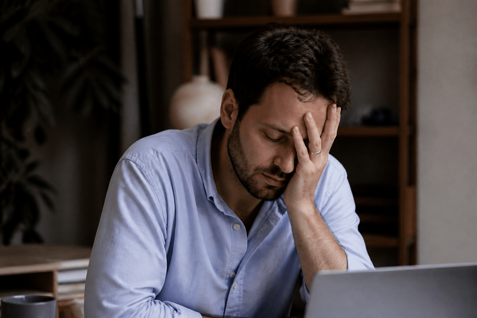 Travailleur fatigué à son bureau tenant sa tête